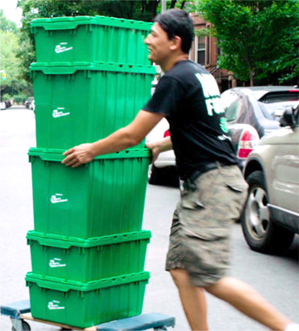 One of Financial District movers NYC with a stack of green reusable moving bins