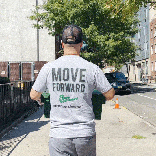 One of professional Nolita movers wearing a Movers, Not Shakers! T-shirt and carrying a box