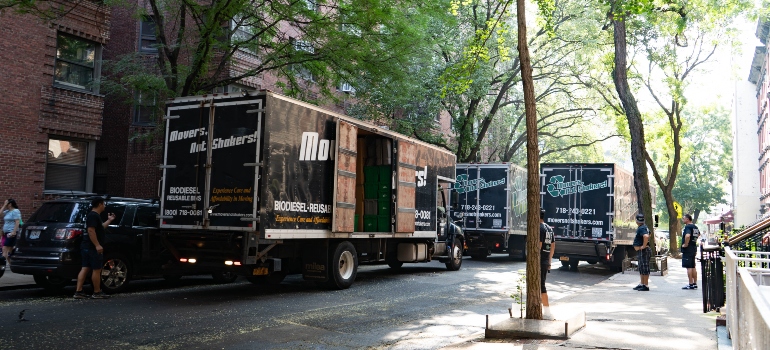Several Movers Not Shakers trucks parked in the street as a way to help organize a last minute move in New York