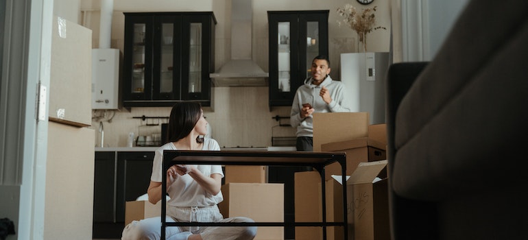 A man woman in the kitchen talking about tips for disassembling and packing your kitchen cabinets;