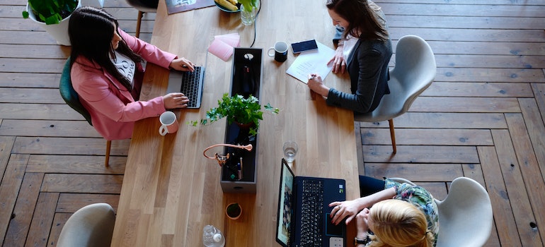 Three women sitting at a desk and working representing a successful NYC commercial relocation