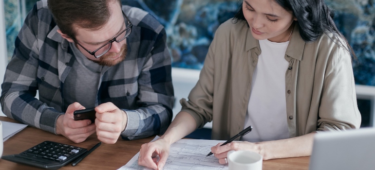 A man and a woman looking at a moving contract and making calculations