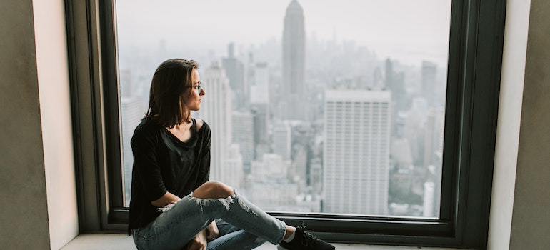 a girl sitting next to the window