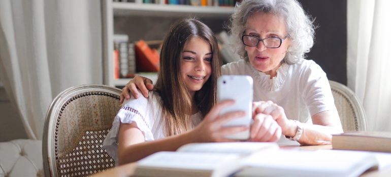 A grandmother and her granddaughter looking at a smartphone
