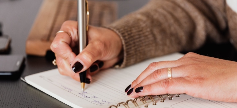 a women writing down notes for decluttering a Manhattan condo before the move