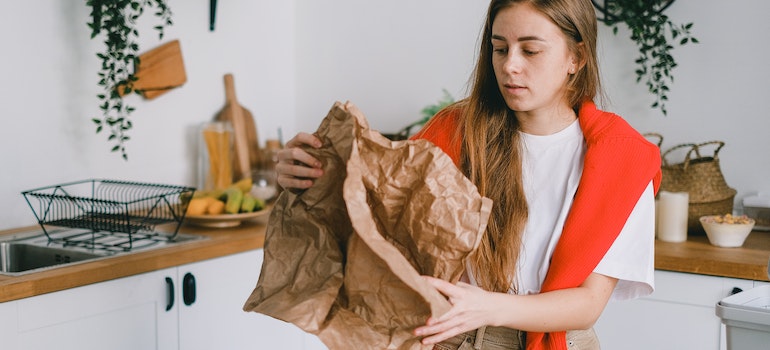 Concentrated woman folding recycled and used paper
