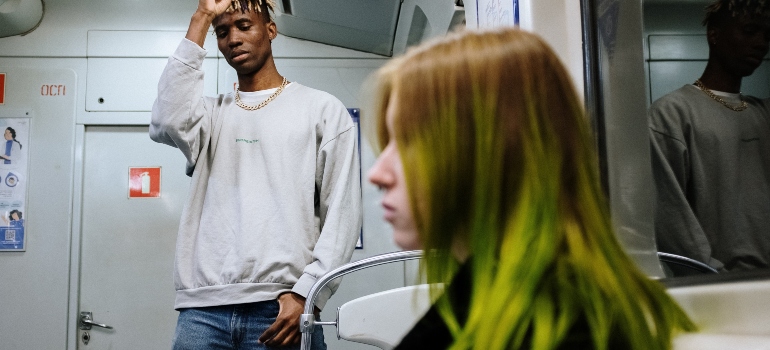 Two people on a subway representing transportation as one of the factors for choosing Brooklyn neighborhoods for commuting to Manhattan