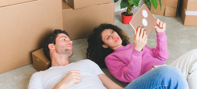 a man and woman lying on the floor trying to prepare for an interstate move from NY