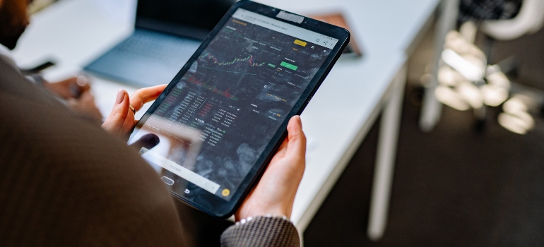 A person holding a tablet looking at a graph about Cobble Hill Housing Market