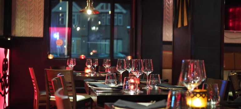 An upscale restaurant with dimmed lights and wine glasses on tables