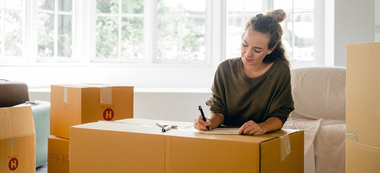 A woman writing on a box