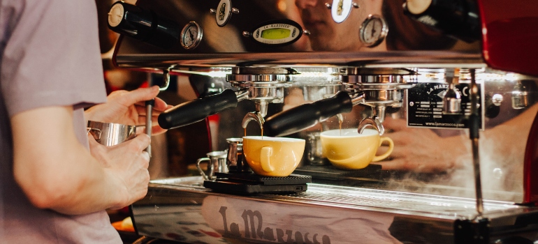 A man making coffee on an espresso machine.