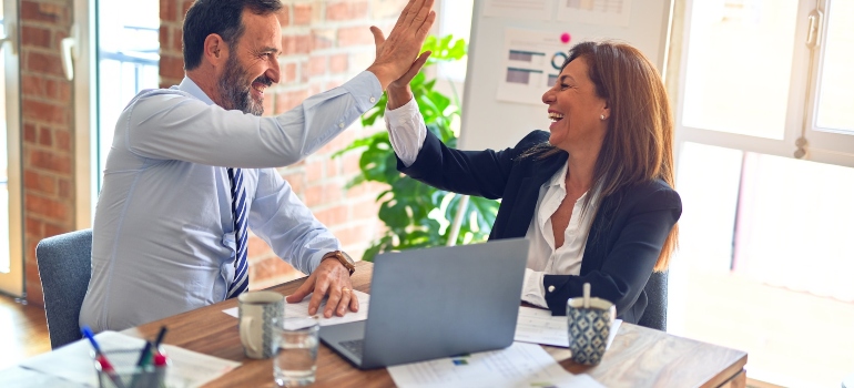 Coworkers high five after planning a successful commercial move in Manhattan