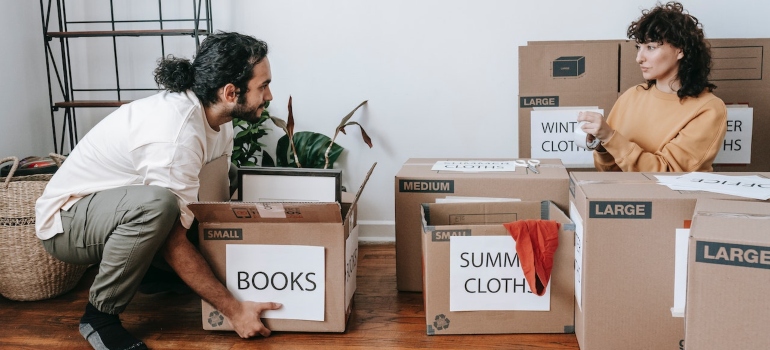 A couple surrounded by labeled moving boxes