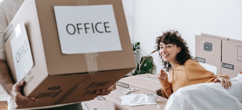 A man carrying a box labeled office