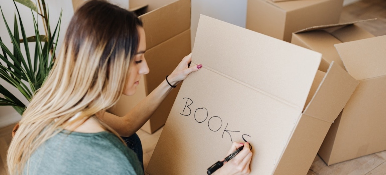 A woman labeling a box