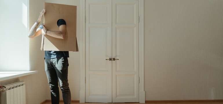 a man with a box on his head trying to handle stress when moving interstate