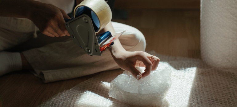 a woman using a tape and bubble wrap