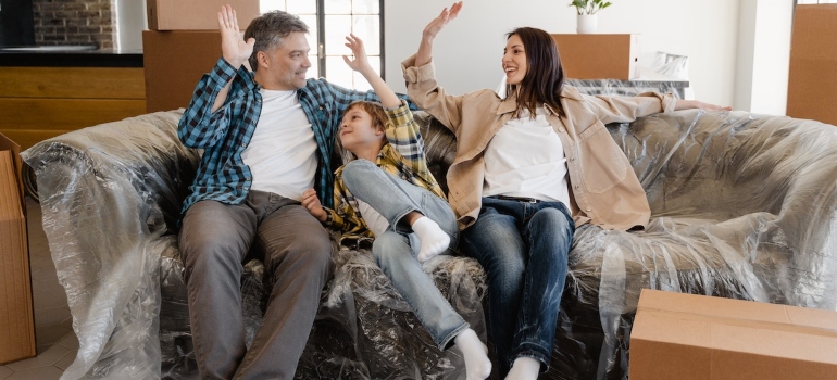 a family sitting on a couch about to unpack after moving to Red Hook