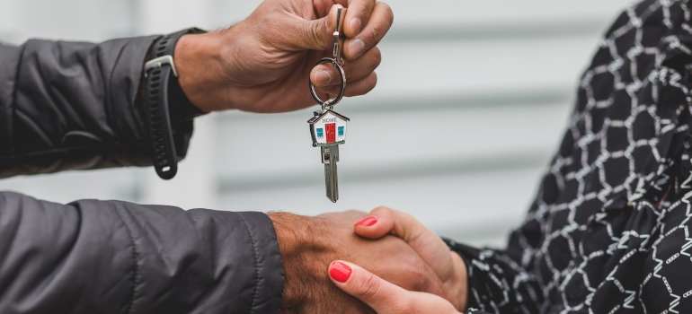 A man giving keys to a woman