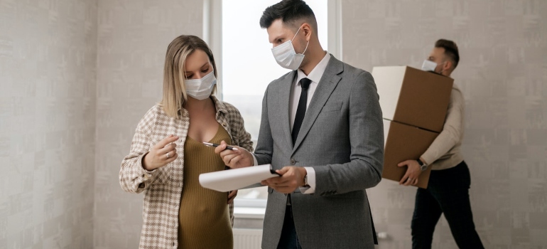 a man talking to a pregnant woman about tips and tricks for moving pregnant