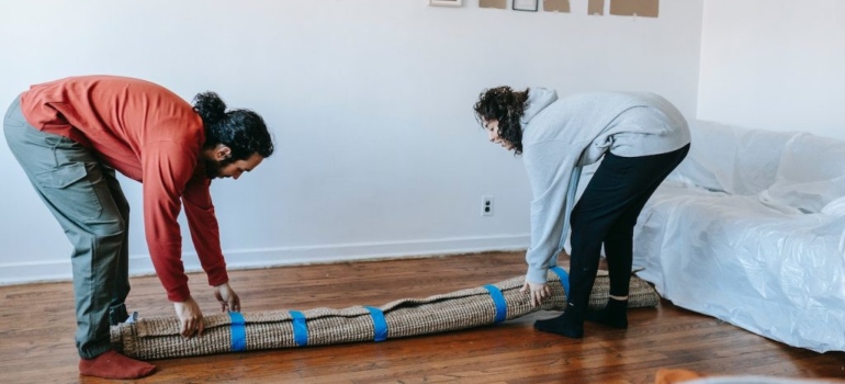 a couple rolling a carpet