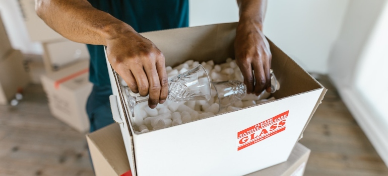 a mover about to pack glassware into the box