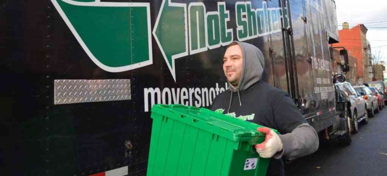 one of the Brighton Beach movers carrying a reusable moving bin