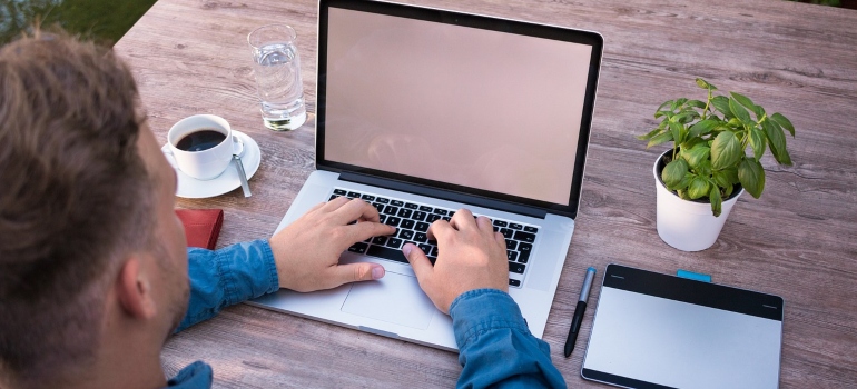 a person using a laptop to check Coney Island VS Dyker Heights