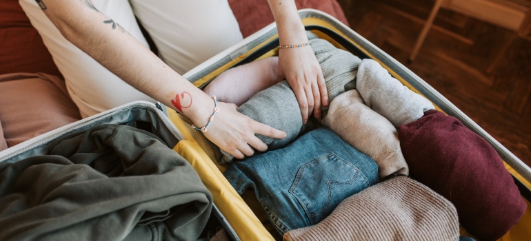 a woman packing clothes as a first step to prepare for the fall move to Kensington